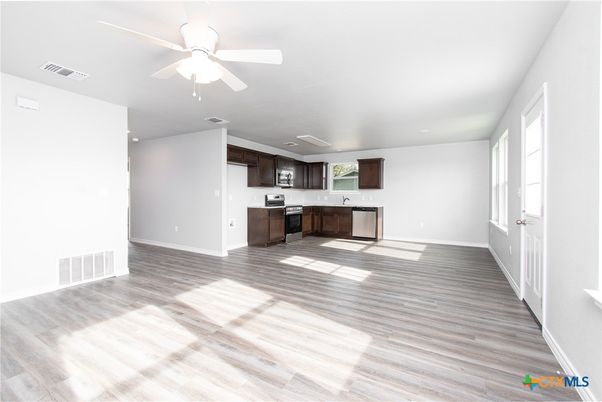 Empty room, Interior, Kitchen, Recessed Lighting, Stainless Steel Appliances, Wood Texture Flooring