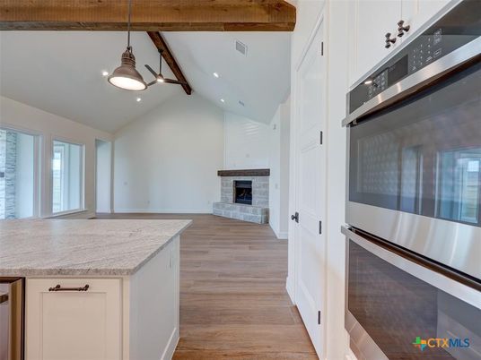 Empty room, Fireplace, Interior, Kitchen, Pendant Lights, Recessed Lighting, Stainless Steel Appliances, Wooden Beams, Wood Texture Flooring