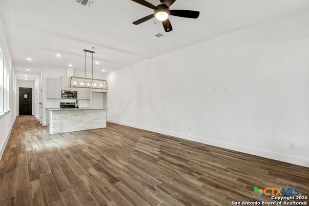 Empty room, Interior, Kitchen, Pendant Lights, Recessed Lighting, Stainless Steel Appliances, Wood Texture Flooring
