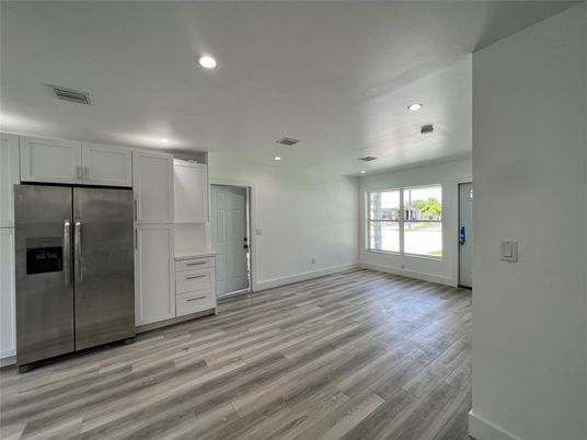 Empty room, Interior, Kitchen, Recessed Lighting, Stainless Steel Appliances, Wood Texture Flooring