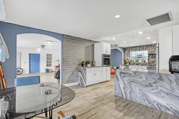 Dining room, Interior, Kitchen, Marble Walls, Recessed Lighting, Stainless Steel Appliances, Wood Texture Flooring