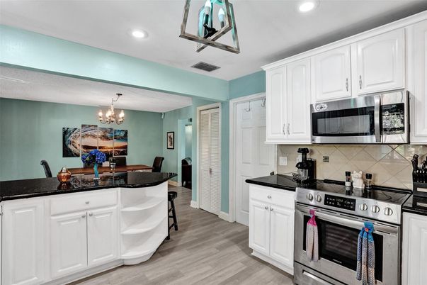 Chandelier, Dining room, Interior, Kitchen, Recessed Lighting, Stainless Steel Appliances, Wood Texture Flooring