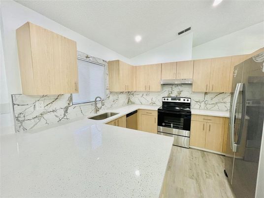 Interior, Kitchen, Marble Walls, Recessed Lighting, Stainless Steel Appliances, Wood Texture Flooring