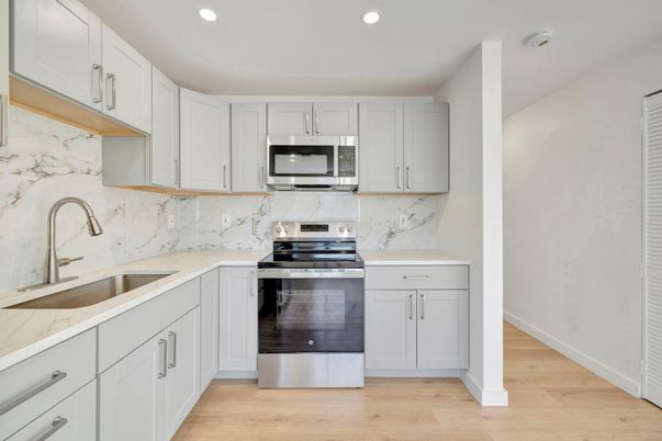 Interior, Kitchen, Marble Walls, Recessed Lighting, Stainless Steel Appliances, Wood Texture Flooring