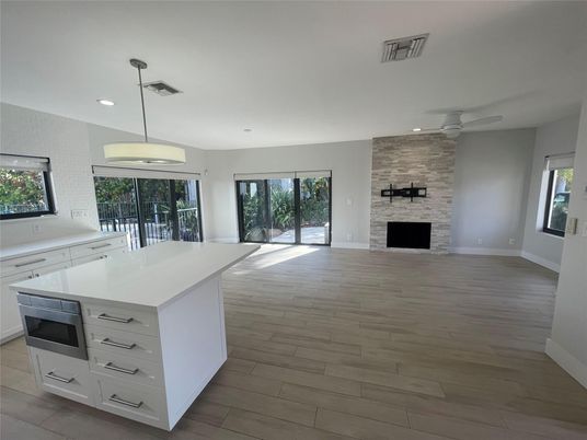 Empty room, Fireplace, Interior, Kitchen, Pendant Lights, Recessed Lighting, Stone Walls, Wood Texture Flooring