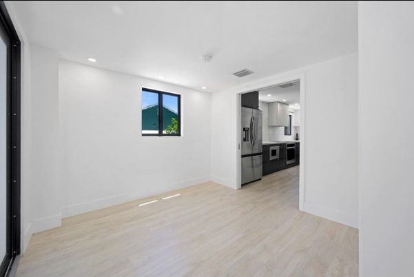 Empty room, Interior, Kitchen, Recessed Lighting, Stainless Steel Appliances, Wood Texture Flooring