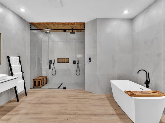Bathroom, Free Standing Baths, Glass Shower, Interior, Marble Walls, Recessed Lighting, Wood Texture Flooring