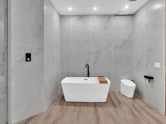 Bathroom, Free Standing Baths, Interior, Marble Walls, Recessed Lighting, Wood Texture Flooring