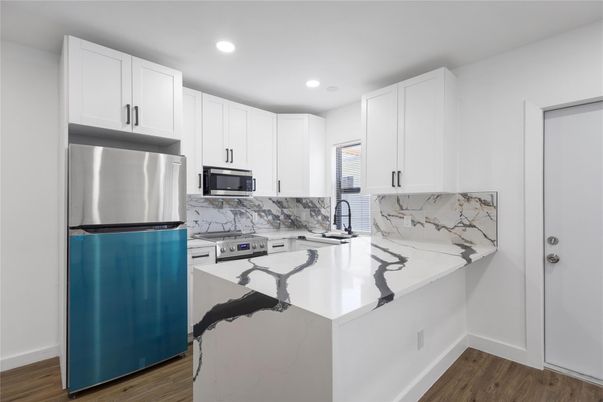 Interior, Kitchen, Marble Walls, Recessed Lighting, Stainless Steel Appliances, Wood Texture Flooring