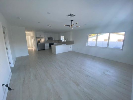 Empty room, Interior, Kitchen, Pendant Lights, Recessed Lighting, Stainless Steel Appliances, Wood Texture Flooring