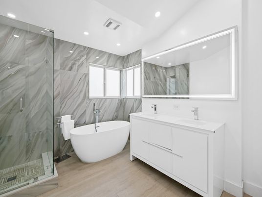 Bathroom, Dual Sink Vanities, Free Standing Baths, Glass Shower, Interior, Marble Walls, Recessed Lighting, Wood Texture Flooring
