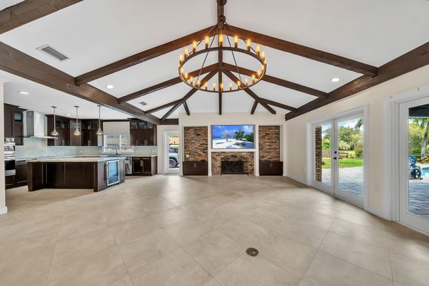 Chandelier, Fireplace, Interior, Kitchen, Pendant Lights, Recessed Lighting, Stainless Steel Appliances, Stone Walls, Wooden Beams