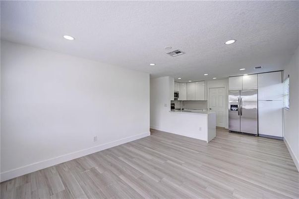 Empty room, Interior, Kitchen, Recessed Lighting, Stainless Steel Appliances, Wood Texture Flooring