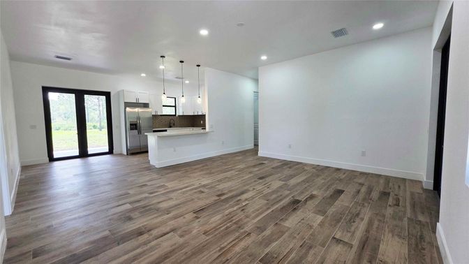 Empty room, Interior, Kitchen, Pendant Lights, Recessed Lighting, Stainless Steel Appliances, Wood Texture Flooring