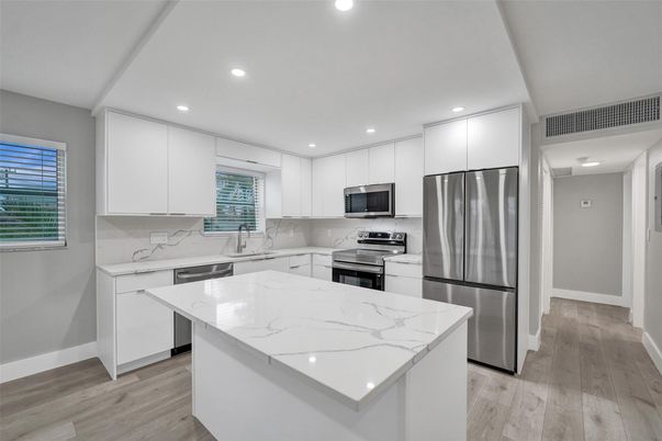 Interior, Kitchen, Marble Walls, Recessed Lighting, Stainless Steel Appliances, Wood Texture Flooring