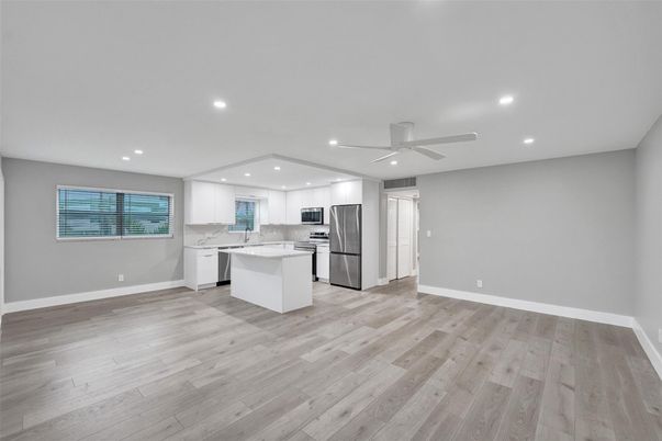 Empty room, Interior, Kitchen, Recessed Lighting, Stainless Steel Appliances, Wood Texture Flooring