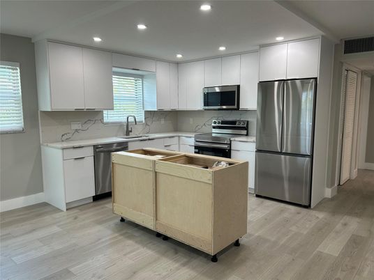 Interior, Kitchen, Marble Walls, Recessed Lighting, Stainless Steel Appliances, Wood Texture Flooring