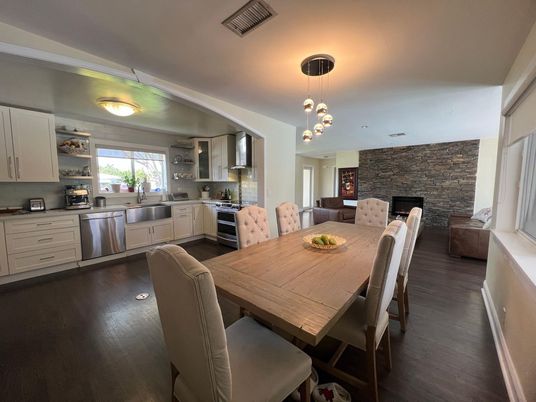 Dining room, Fireplace, Interior, Kitchen, Pendant Lights, Stainless Steel Appliances, Stone Walls, Wood Texture Flooring