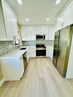 Interior, Kitchen, Marble Walls, Recessed Lighting, Stainless Steel Appliances, Wood Texture Flooring