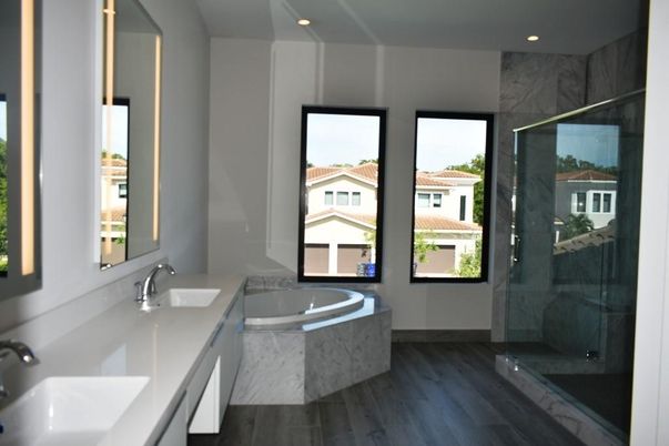Bathroom, Dual Sink Vanities, Glass Shower, Interior, Marble Walls, Recessed Lighting, Wood Texture Flooring