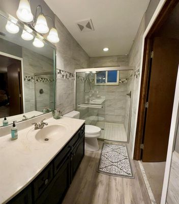 Bathroom, Dual Sink Vanities, Glass Shower, Interior, Marble Walls, Recessed Lighting, Wood Texture Flooring