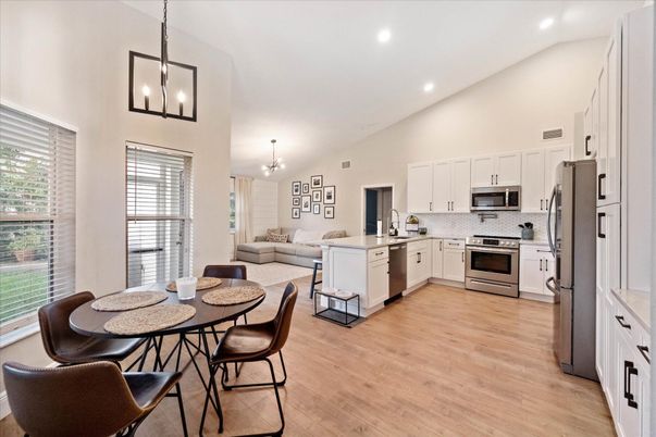 Chandelier, Dining room, Interior, Kitchen, Living room, Pendant Lights, Recessed Lighting, Stainless Steel Appliances, Wood Texture Flooring