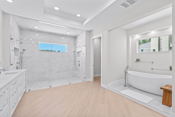 Bathroom, Dual Sink Vanities, Free Standing Baths, Glass Shower, Interior, Marble Walls, Recessed Lighting, Wood Texture Flooring