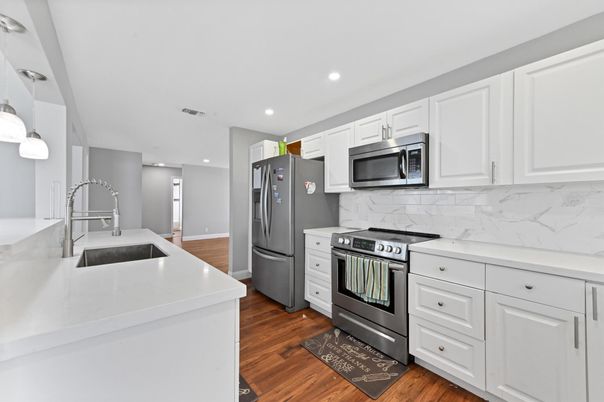 Interior, Kitchen, Marble Walls, Recessed Lighting, Stainless Steel Appliances, Wood Texture Flooring