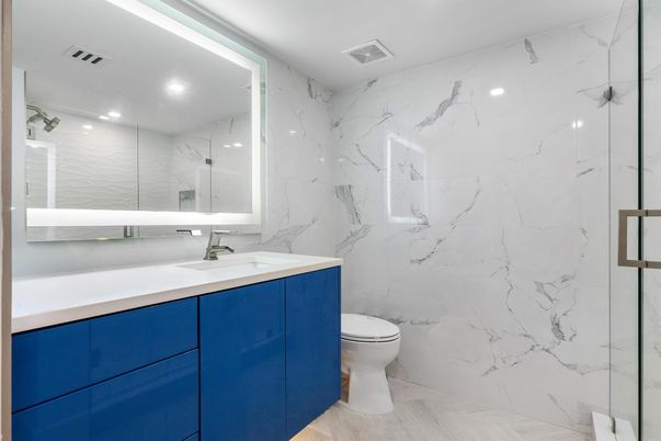 Bathroom, Dual Sink Vanities, Glass Shower, Interior, Marble Walls, Recessed Lighting, Wood Texture Flooring