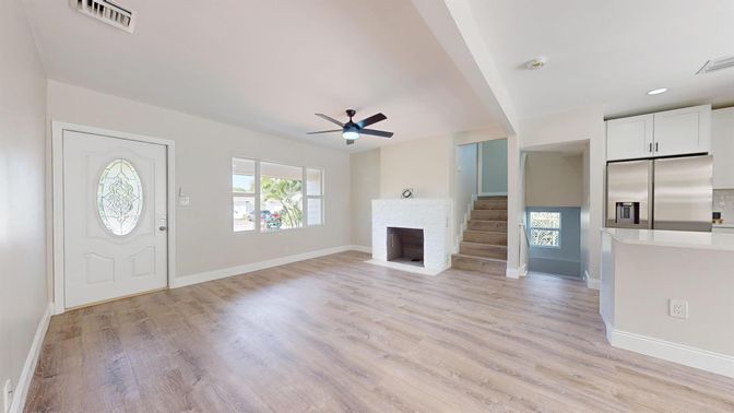 Empty room, Fireplace, Interior, Kitchen, Recessed Lighting, Stainless Steel Appliances, Wood Texture Flooring