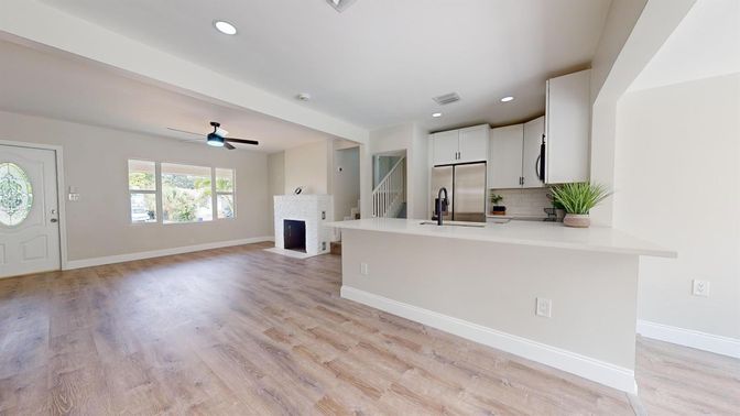 Empty room, Fireplace, Interior, Kitchen, Recessed Lighting, Stainless Steel Appliances, Wood Texture Flooring