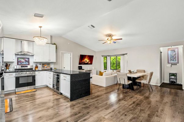Chandelier, Dining room, Fireplace, Interior, Kitchen, Living room, Stainless Steel Appliances, Wood Texture Flooring