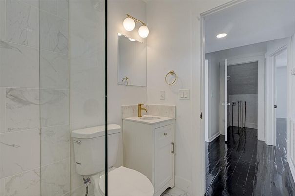 Bathroom, Dual Sink Vanities, Glass Shower, Interior, Marble Walls, Recessed Lighting, Wood Texture Flooring