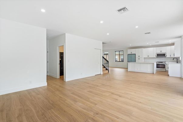 Empty room, Interior, Kitchen, Recessed Lighting, Stainless Steel Appliances, Wood Texture Flooring