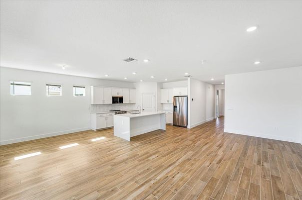 Empty room, Interior, Kitchen, Recessed Lighting, Stainless Steel Appliances, Wood Texture Flooring
