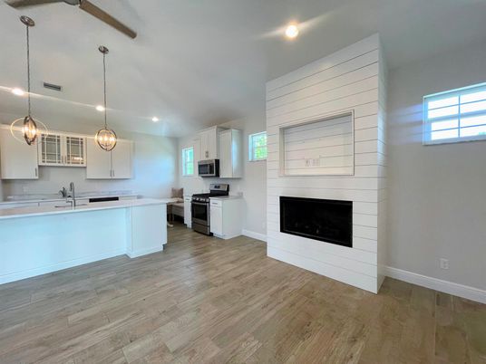 Empty room, Fireplace, Interior, Kitchen, Pendant Lights, Recessed Lighting, Wood Texture Flooring