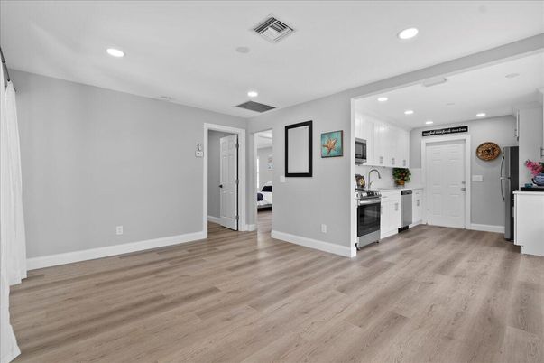 Empty room, Interior, Kitchen, Recessed Lighting, Stainless Steel Appliances, Wood Texture Flooring