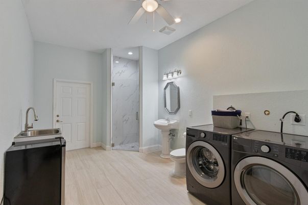 Bathroom, Dual Sink Vanities, Interior, Marble Walls, Recessed Lighting, Washer, Wood Texture Flooring