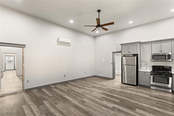 Empty room, Interior, Kitchen, Recessed Lighting, Stainless Steel Appliances, Wood Texture Flooring