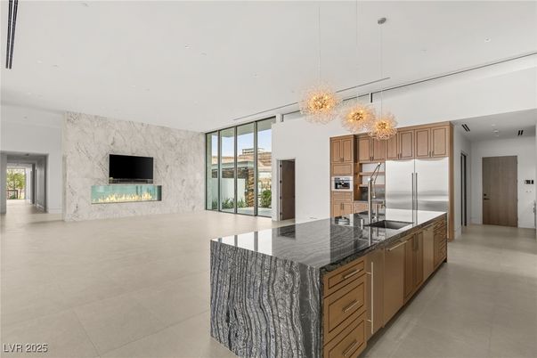 Chandelier, Fireplace, Interior, Kitchen, Marble Walls, Pendant Lights, Recessed Lighting, Stainless Steel Appliances