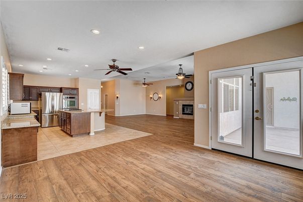 Empty room, Fireplace, Interior, Kitchen, Recessed Lighting, Stainless Steel Appliances, Wood Texture Flooring