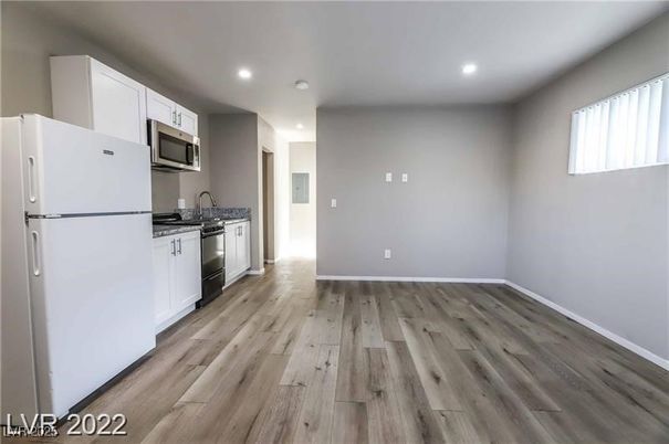 Empty room, Interior, Kitchen, Recessed Lighting, Stainless Steel Appliances, Wood Texture Flooring