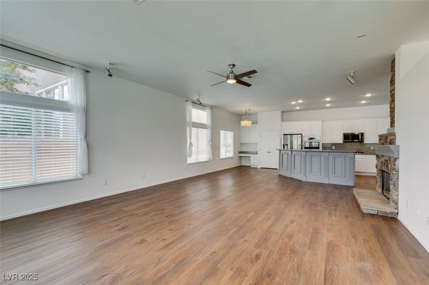 Empty room, Fireplace, Interior, Kitchen, Pendant Lights, Recessed Lighting, Stainless Steel Appliances, Wood Texture Flooring