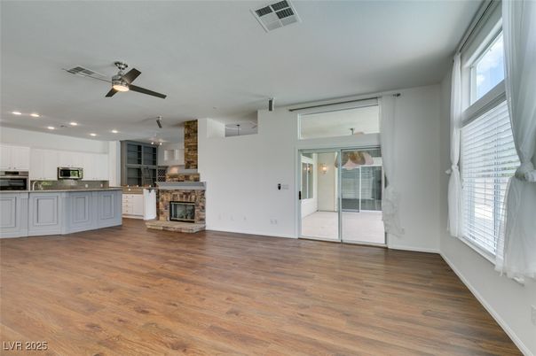 Empty room, Fireplace, Interior, Kitchen, Pendant Lights, Recessed Lighting, Stainless Steel Appliances, Wood Texture Flooring