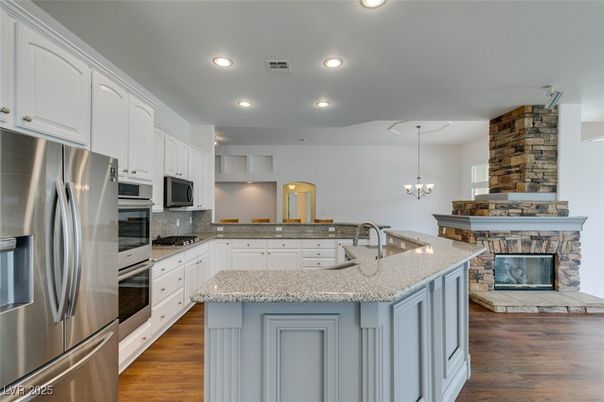 Chandelier, Fireplace, Interior, Kitchen, Recessed Lighting, Stainless Steel Appliances, Wood Texture Flooring