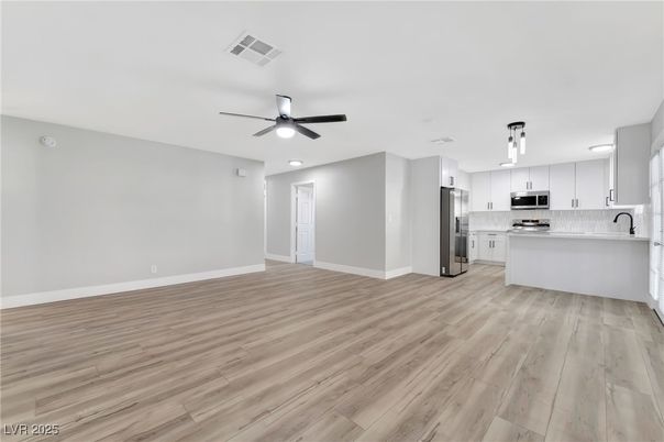 Empty room, Interior, Kitchen, Recessed Lighting, Stainless Steel Appliances, Wood Texture Flooring
