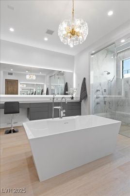 Bathroom, Chandelier, Free Standing Baths, Glass Shower, Interior, Marble Walls, Pendant Lights, Recessed Lighting, Wood Texture Flooring