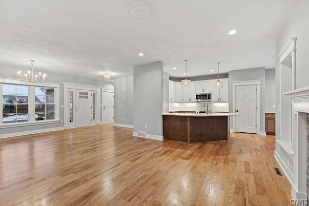 Chandelier, Fireplace, Interior, Kitchen, Pendant Lights, Recessed Lighting, Stainless Steel Appliances, Wood Texture Flooring