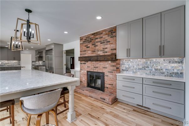 Fireplace, Interior, Kitchen, Pendant Lights, Recessed Lighting, Stainless Steel Appliances, Stone Walls, Wood Texture Flooring