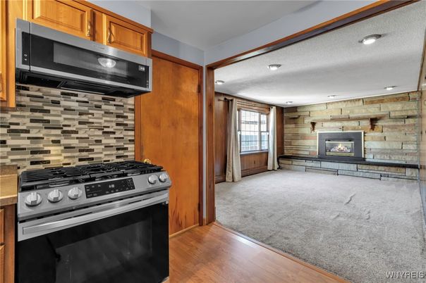 Fireplace, Interior, Kitchen, Recessed Lighting, Stainless Steel Appliances, Stone Walls, Wood Texture Flooring, Wooden Walls
